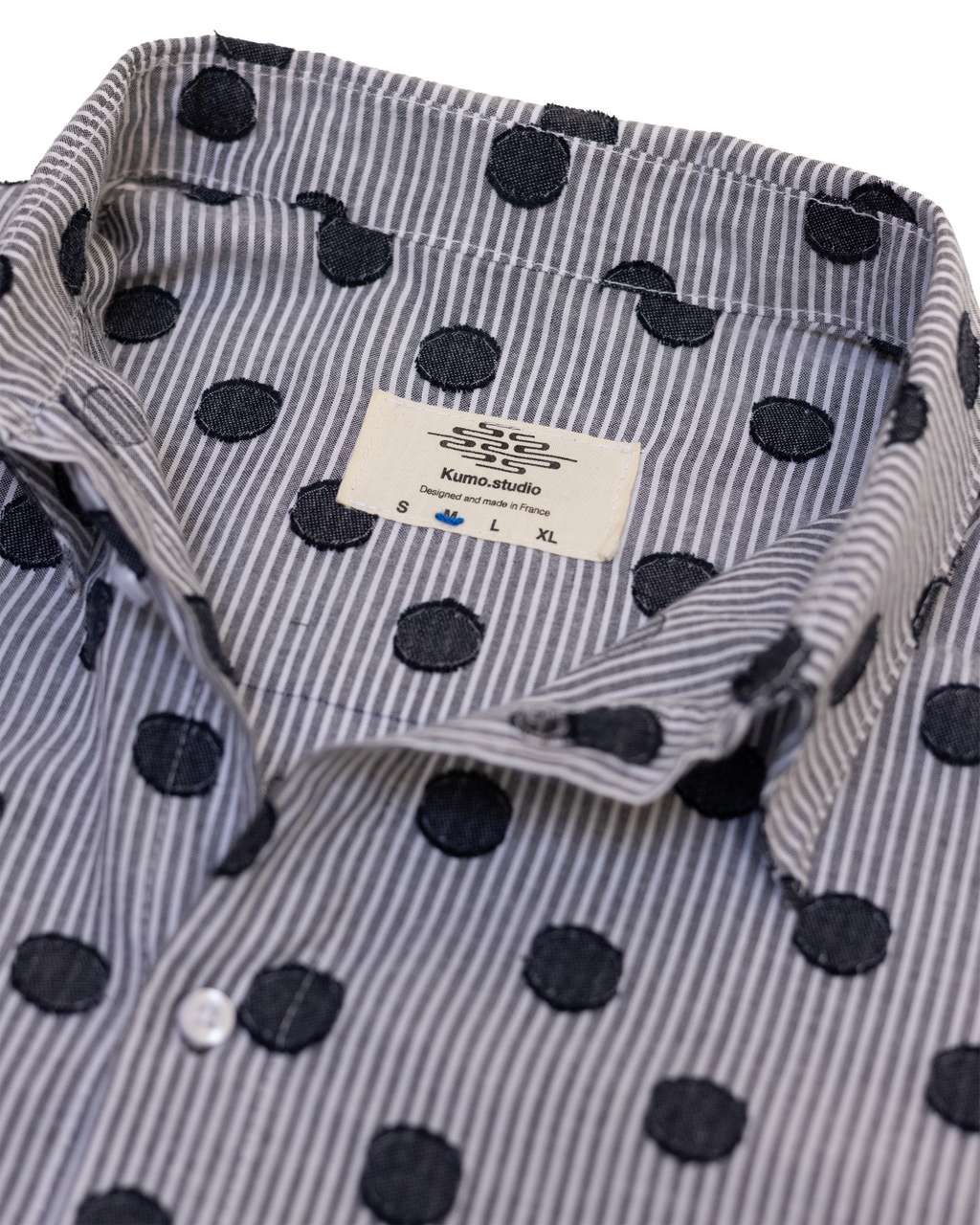 Chemise à la coupe longue et décontractée, pensée pour offrir un tombé fluide et une grande liberté de mouvement.
Conçue et confectionnée à la main en France, dans notre atelier Kumo.studio.
Réalisée dans un tissu en mélange de coton, doux au toucher et sourcé au Japon, elle se distingue par son ourlet asymétrique, légèrement plus long dans le dos, apportant relief et superposition à la silhouette.
